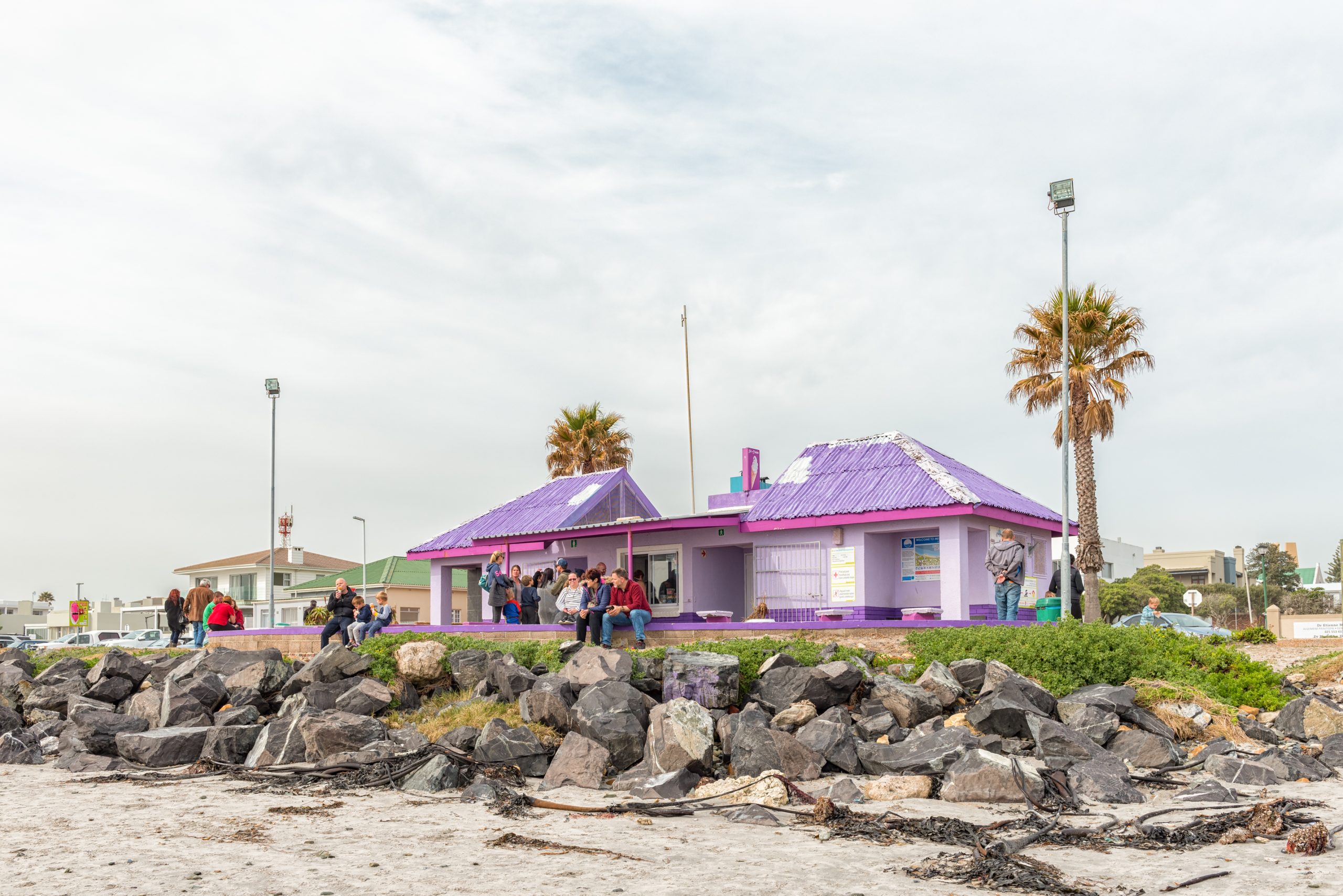 MELKBOSSTRAND, SOUTH AFRICA, AUGUST 19, 2018: A beach scene in Melkbosstrand in the Western Cape Province. A kiosk, toilets and people are visible